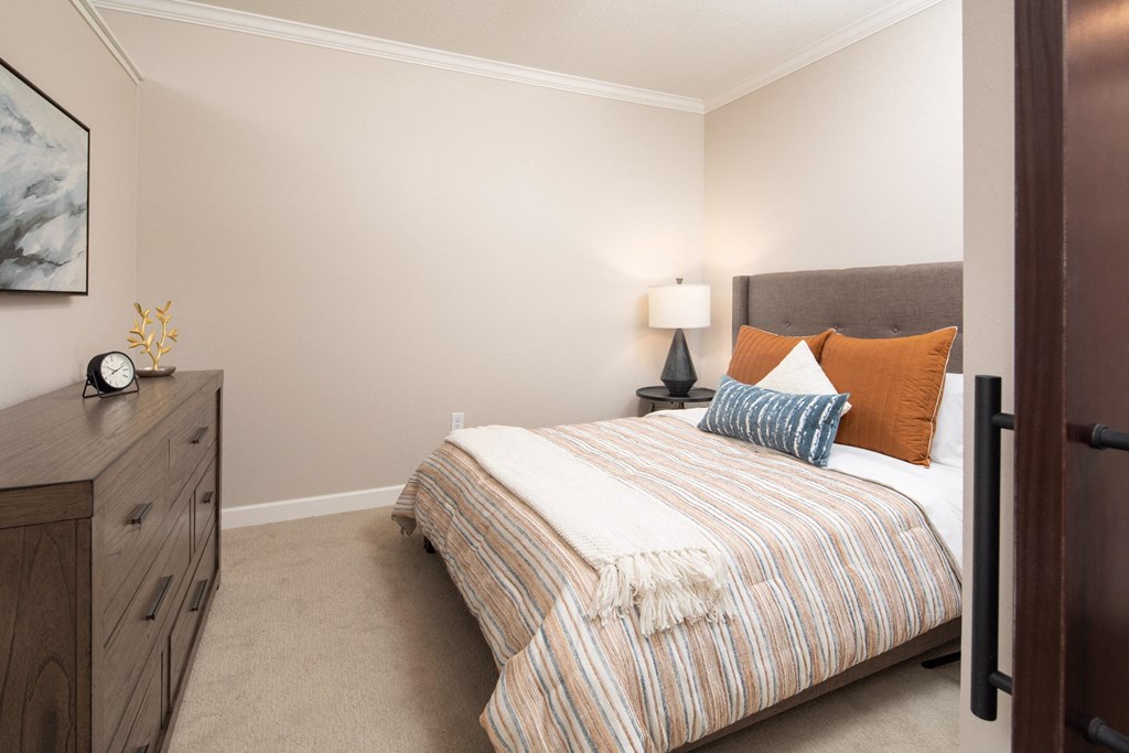 View of model bedroom with bed and dresser  at The Whitley, St. Paul, MN