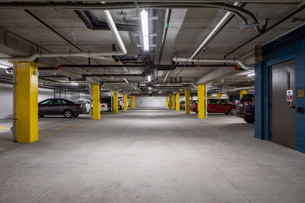 a parking garage with cars and yellow pillars at The Gallery Apartments, Burnsville, 55337