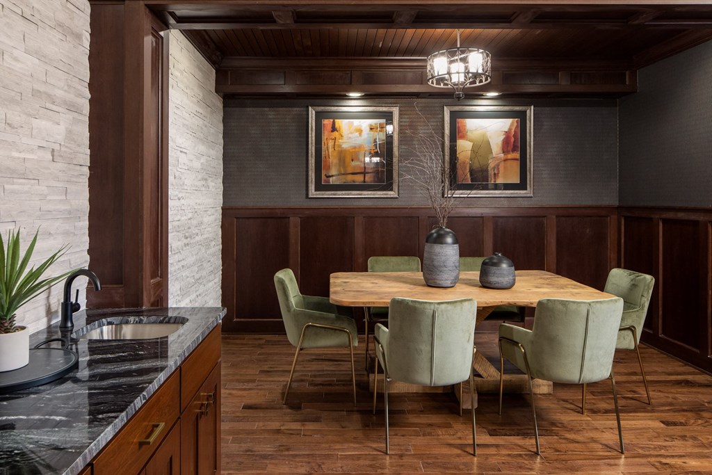 a common area with a wooden table and green chairs at The Gallery Apartments, Burnsville, MN, 55337