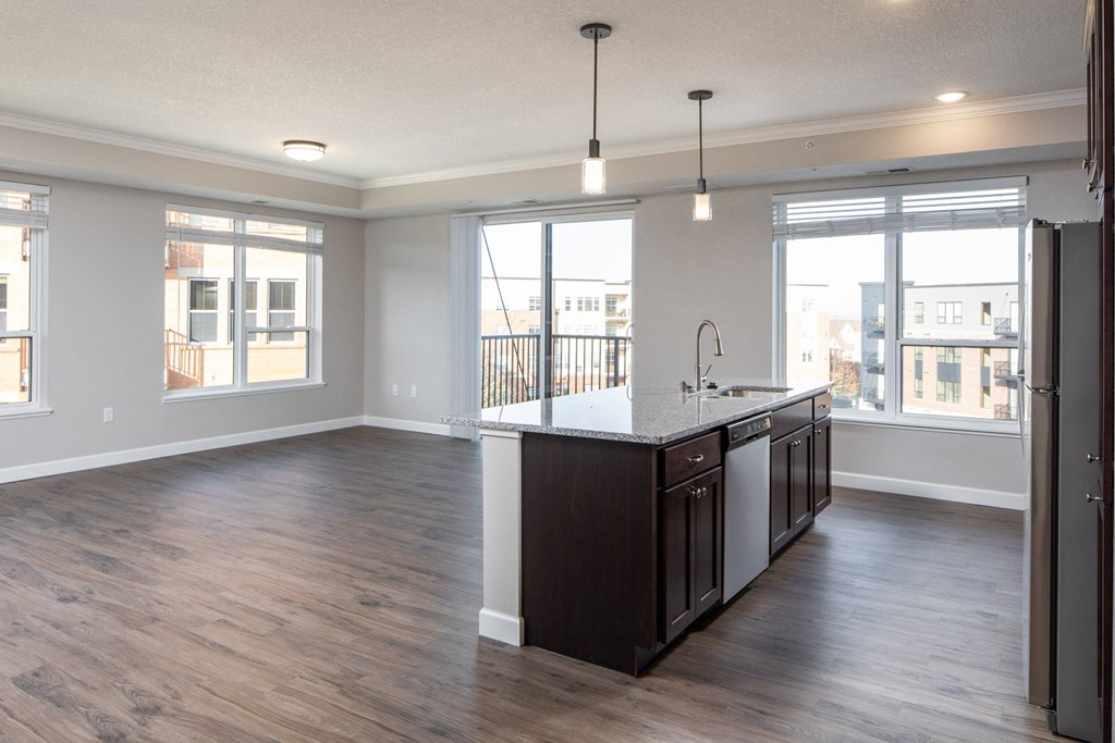an empty living room with a kitchen at The Gallery Apartments, Burnsville, MN