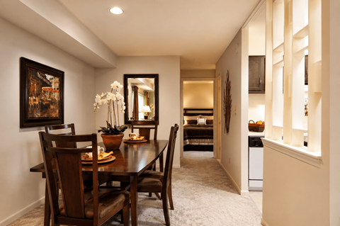 A dining room with a wooden table and chairs.