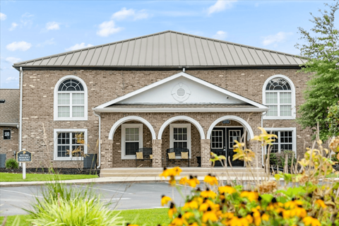 A building with a grey roof and a black door.at Puller Place Apartments, Jacksonville, NC