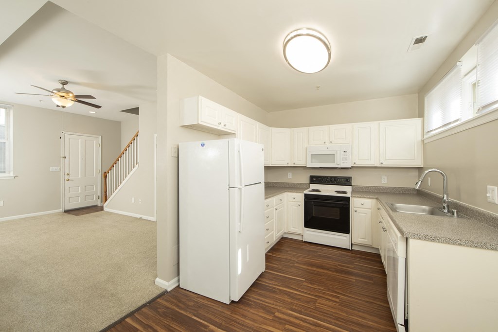 an empty kitchen with white cabinets and a white refrigerator at Queen Anne Belvedere, Baltimore, Maryland