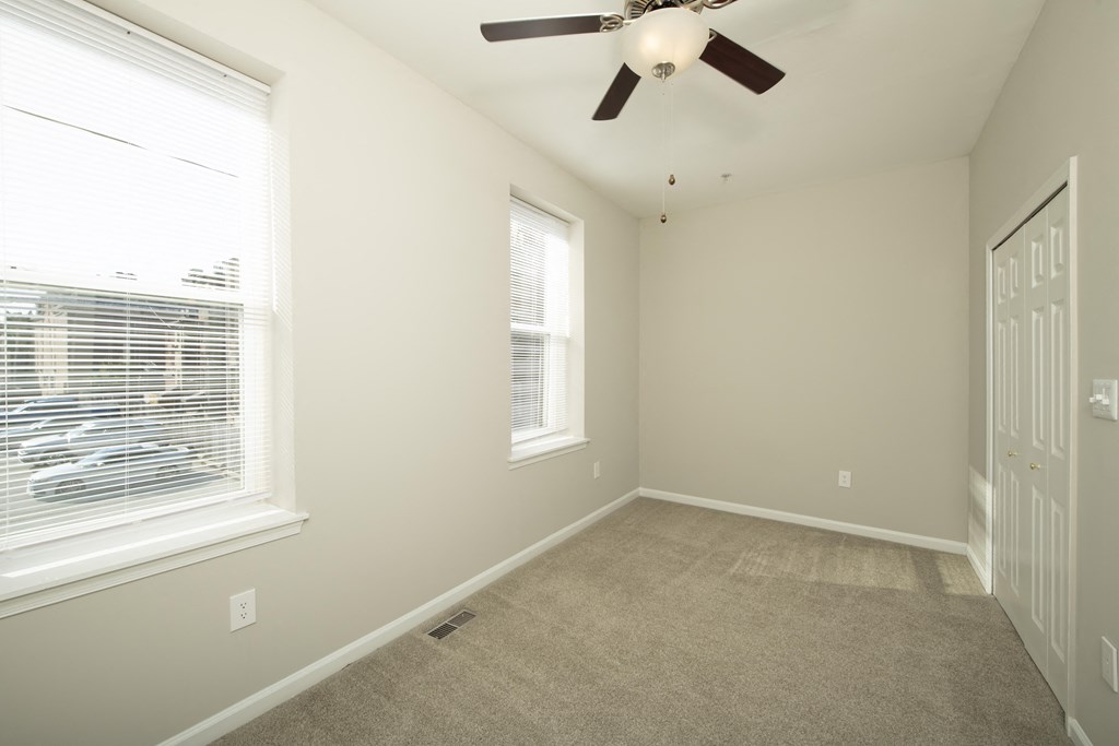 an empty bedroom with a ceiling fan and two windows at Queen Anne Belvedere, Baltimore, MD