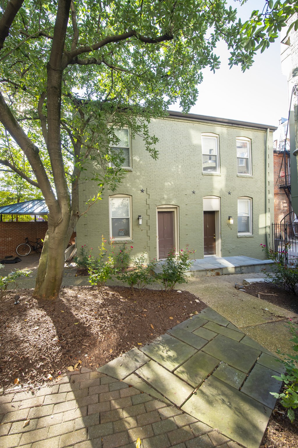 the front of a house with a sidewalk and a tree at Queen Anne Belvedere, Baltimore, MD