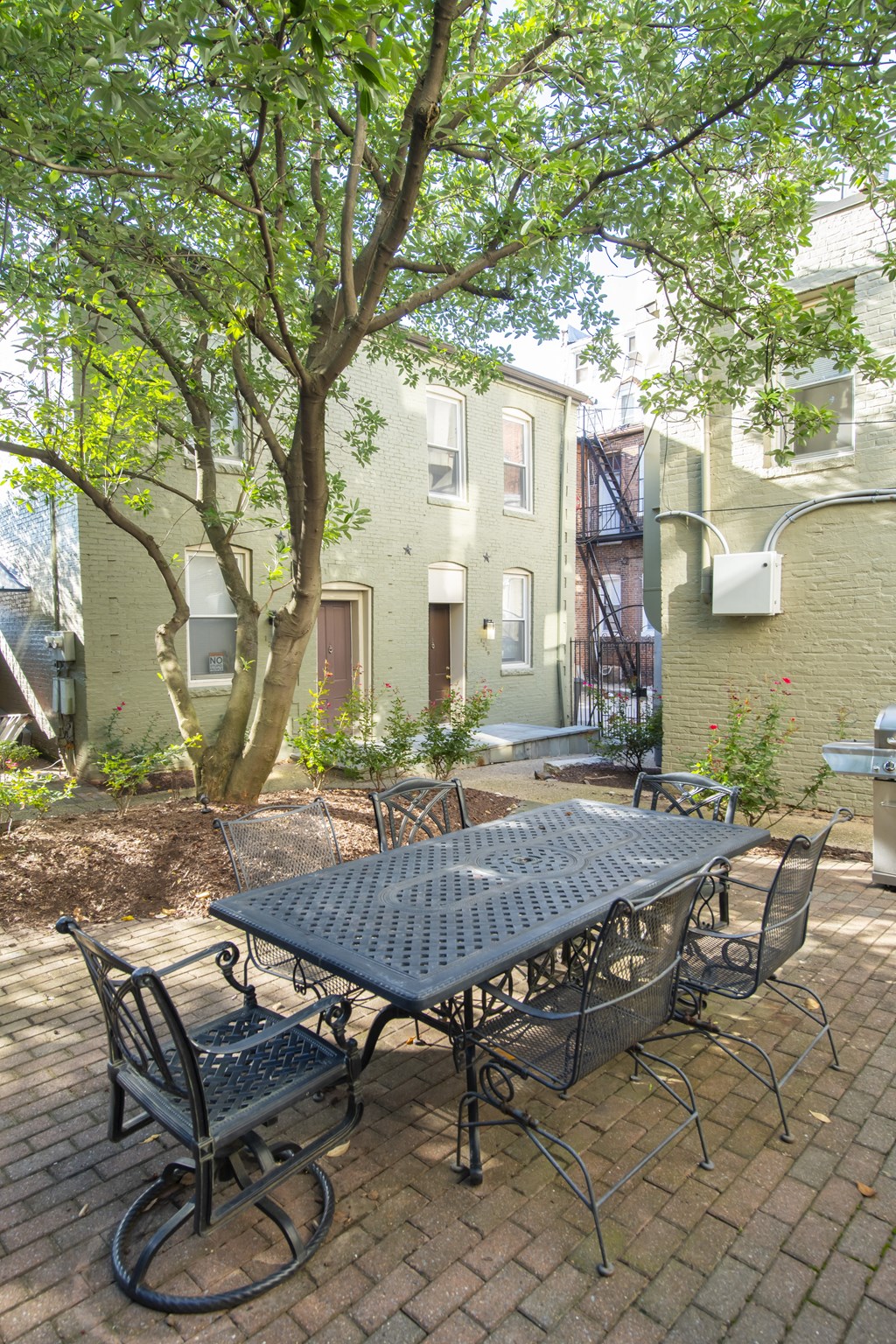 a patio with a table and chairs and a tree at Queen Anne Belvedere, Baltimore