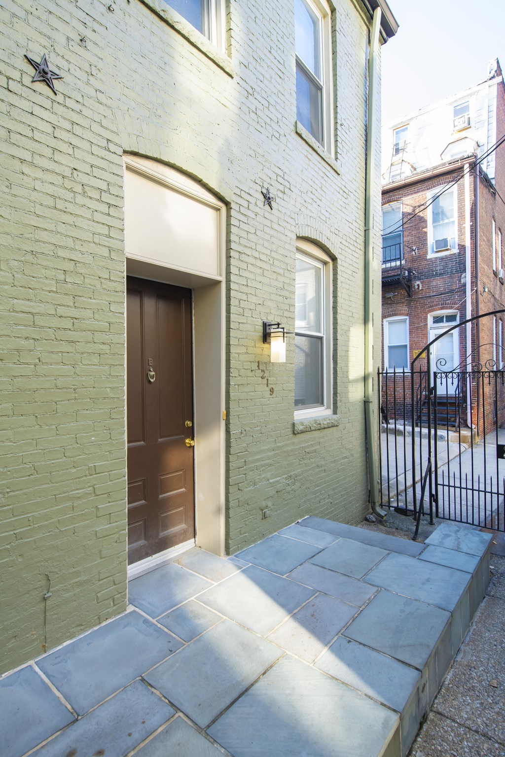 the front door of a brick house with a brown door at Queen Anne Belvedere, Baltimore, MD