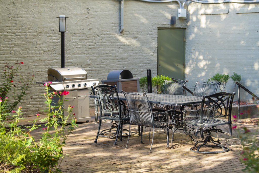 a patio with a table and chairs and a grill at Queen Anne Belvedere, Baltimore