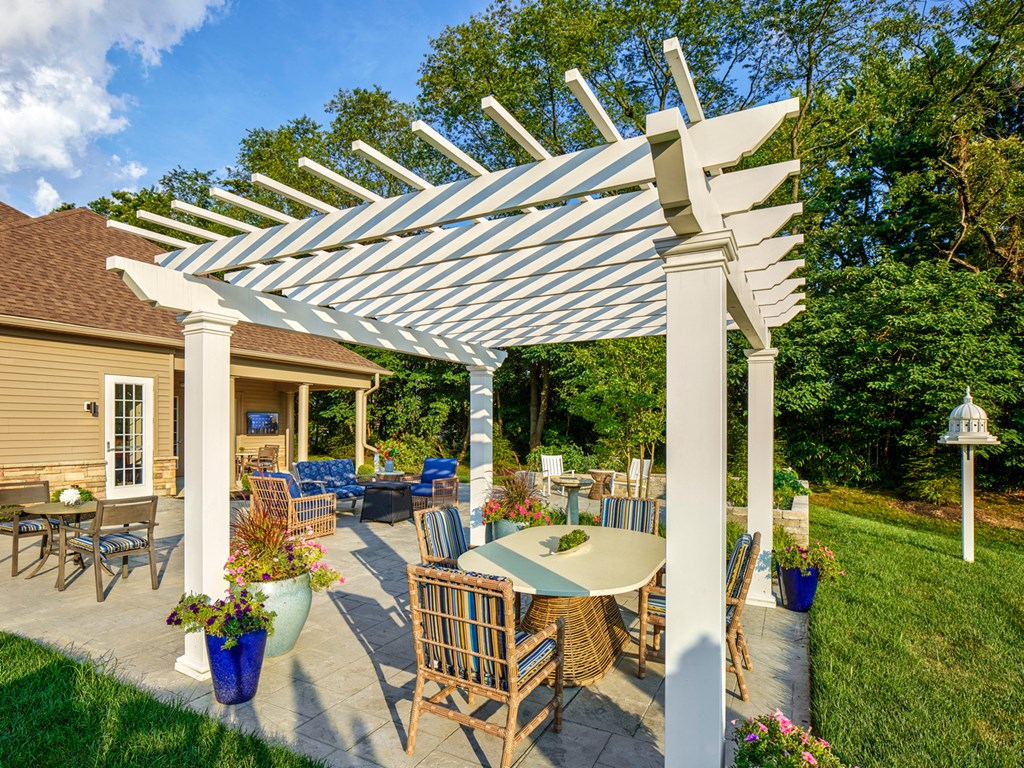 a pergola with a table and chairs on a patio
