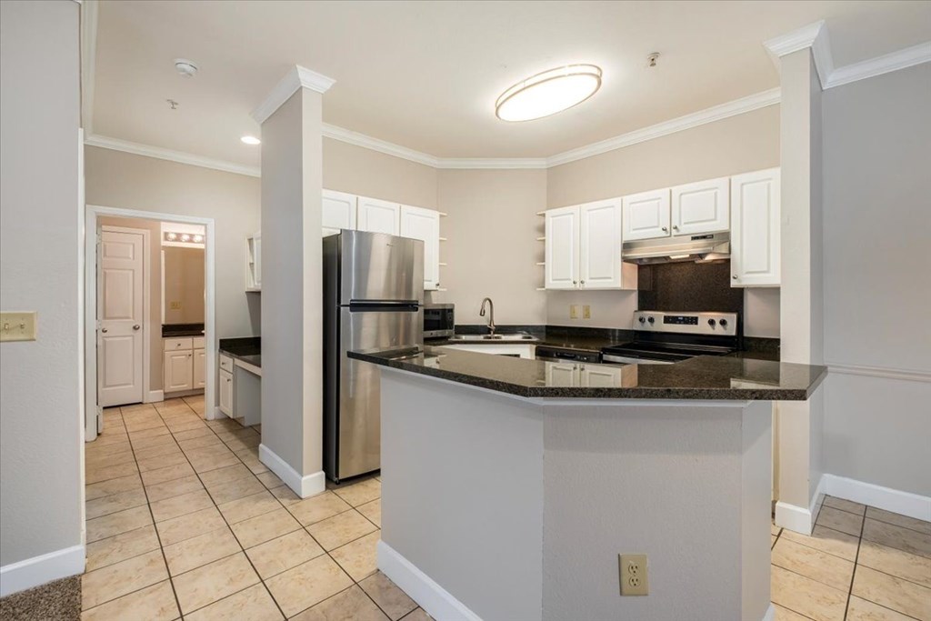 A kitchen with a refrigerator, stove, and oven. at Puller Place Apartments, Jacksonville, NC