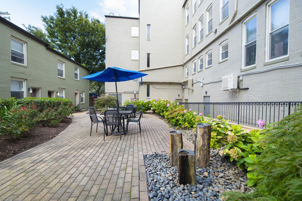 a patio with a table and chairs and an umbrella at Queen Anne Belvedere, Baltimore, Maryland