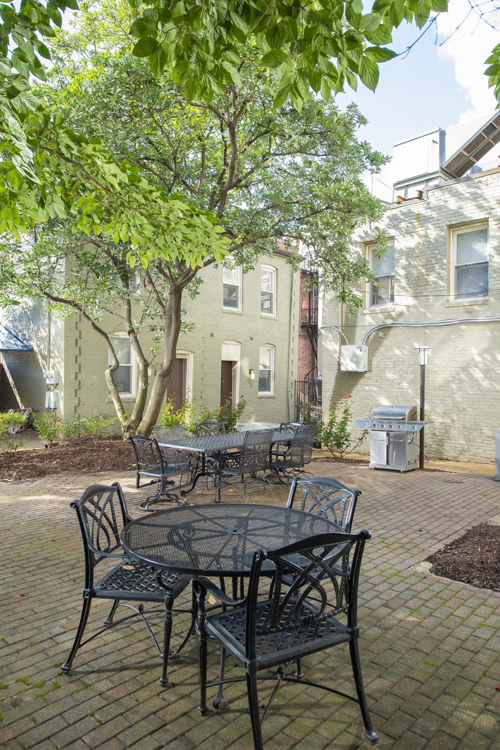 a patio with a table and chairs in front of a building at Queen Anne Belvedere, Baltimore, MD 21201