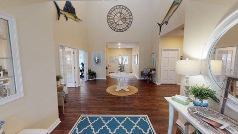 A living room with a rug and a circular decoration on the ceiling.