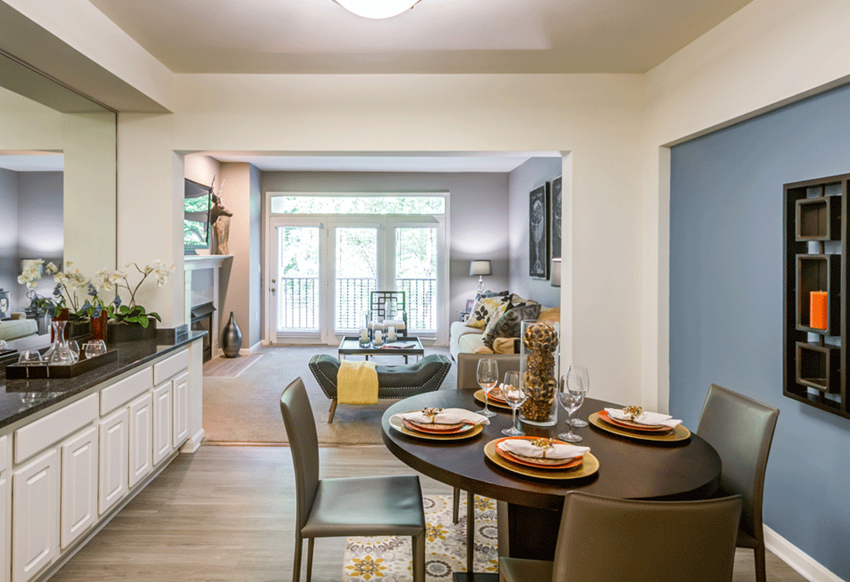 a living room and dining room with a table and chairs