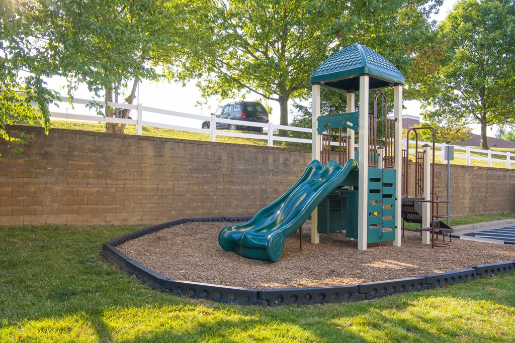 a playground with a slide in a park at Townes at Village Center Apartments, Reisterstown, 21136