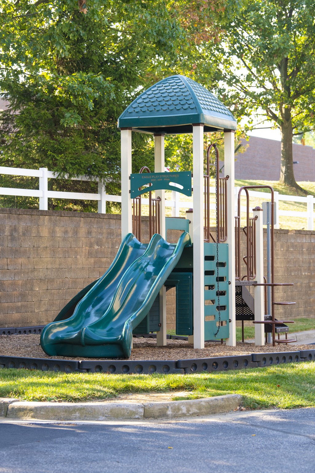 a playground with a slide and a swing set at Townes at Village Center Apartments, Reisterstown, MD