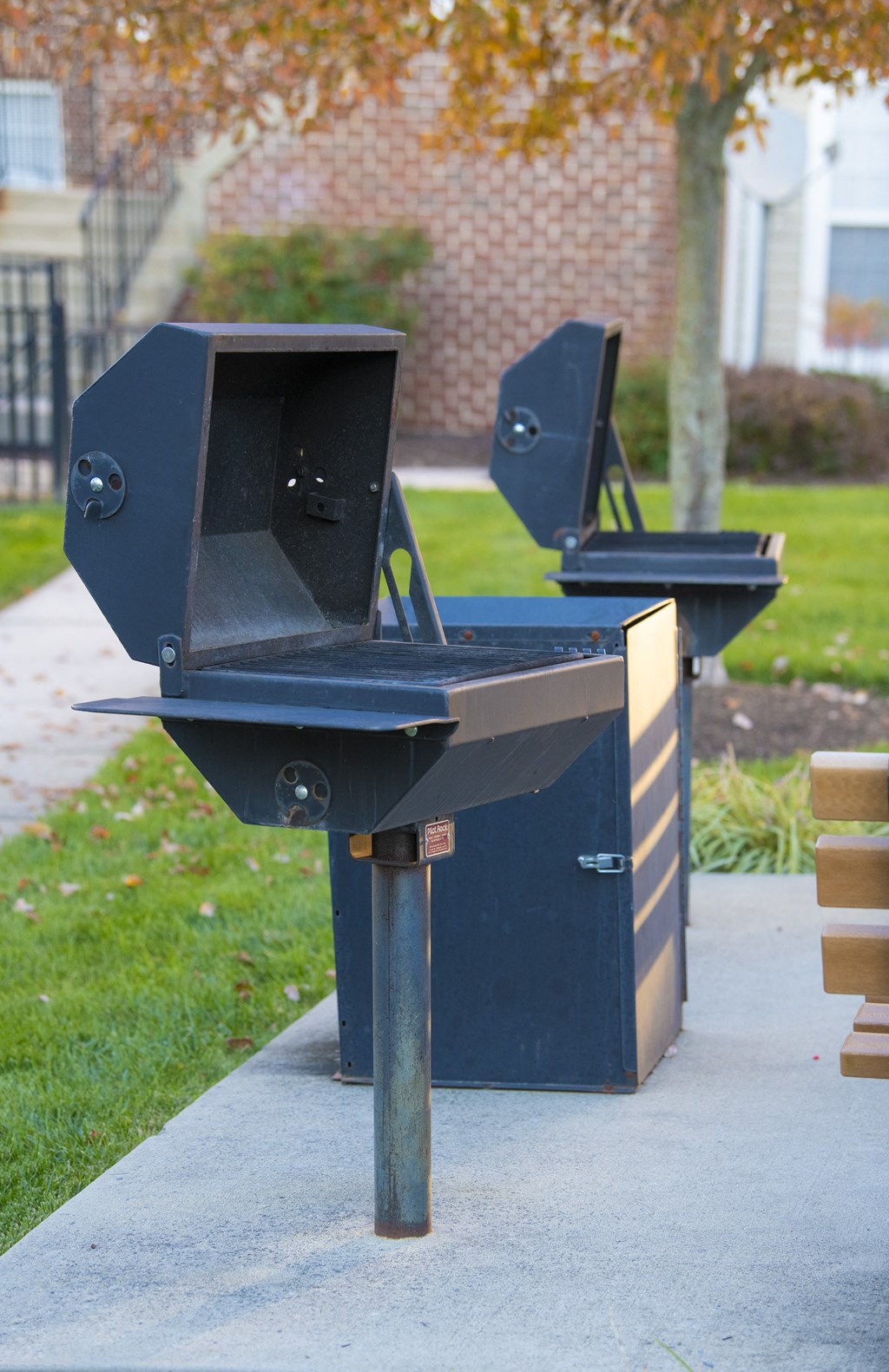two bbq pits on the side of a sidewalk at Townes at Village Center Apartments, Reisterstown, MD