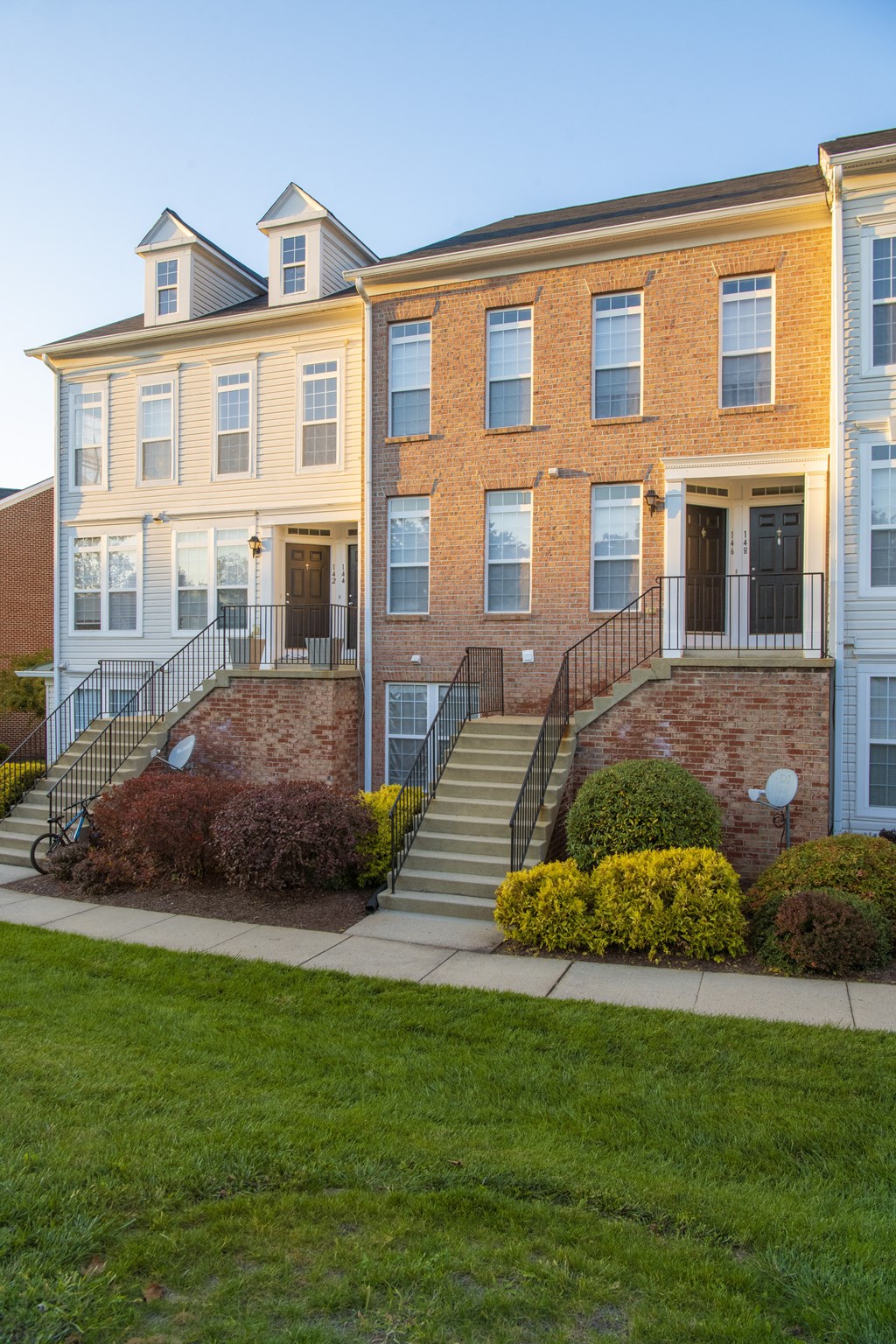 a large brick building with stairs in front of it at Townes at Village Center Apartments, Reisterstown, MD, 21136