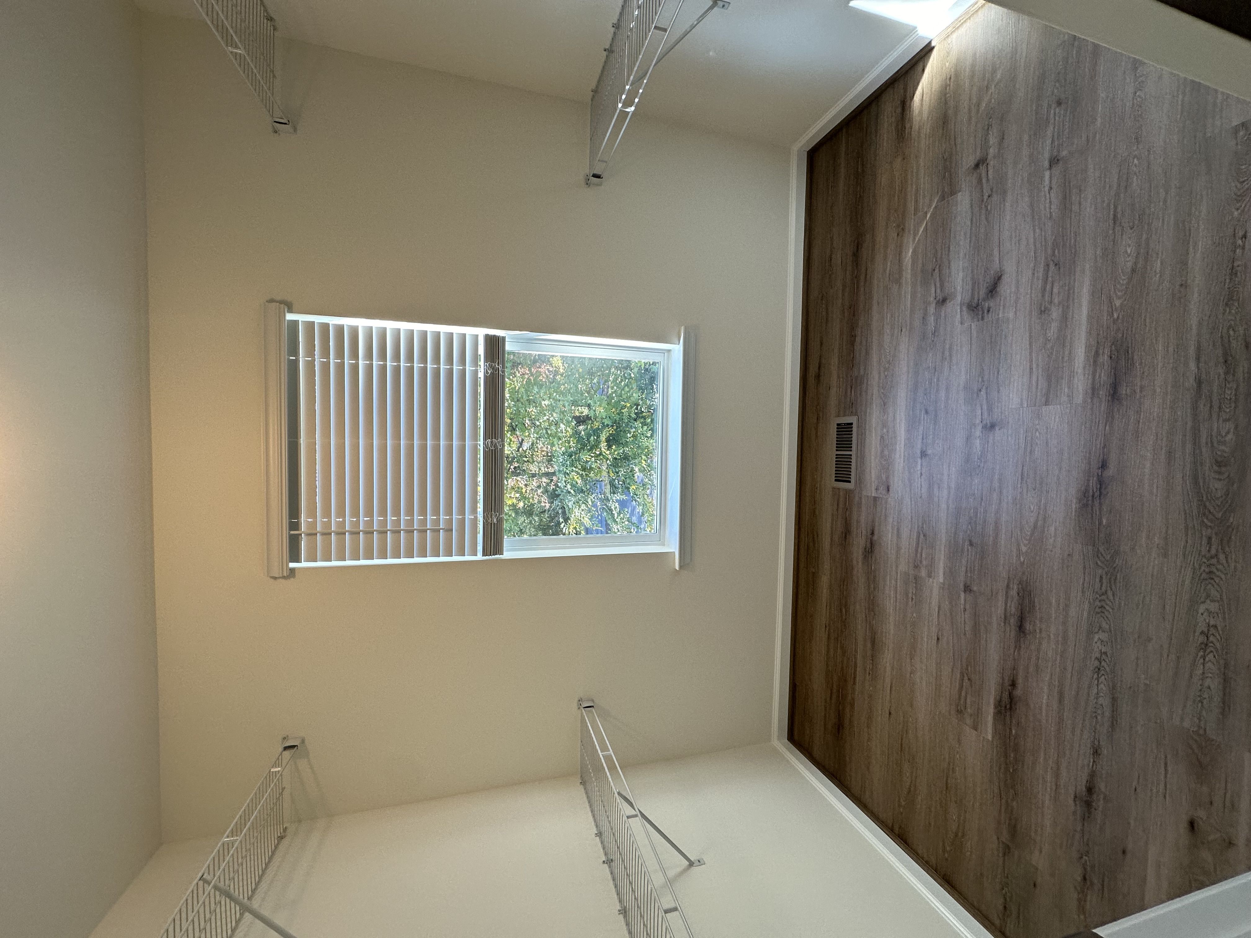 A room with a window and a wooden door.