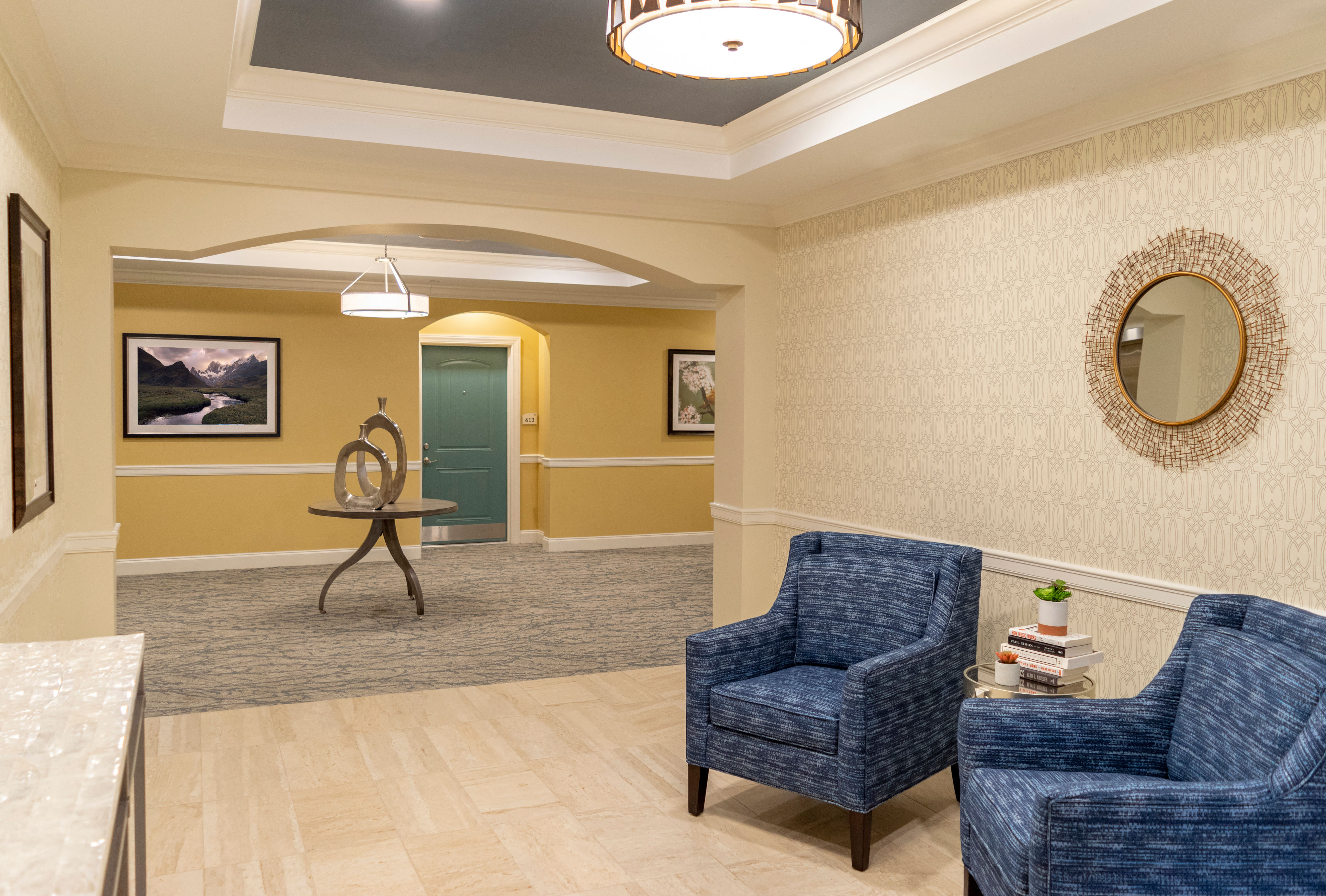 a lobby with blue chairs and a table and a mirror