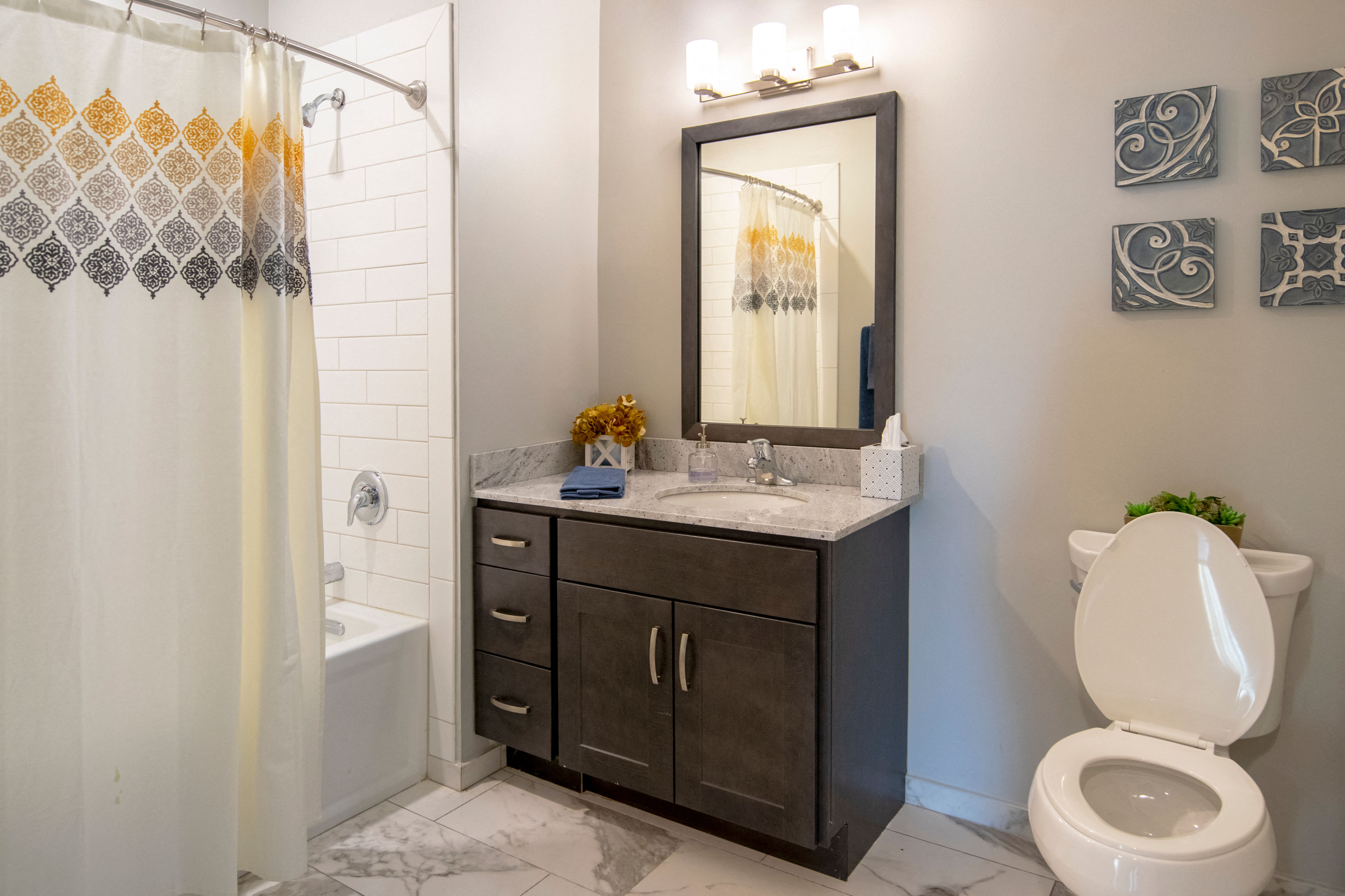 a bathroom with a toilet sink and shower and a mirror