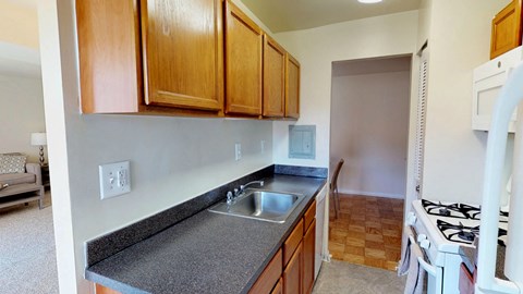 A kitchen with wooden cabinets and a white stove top oven.