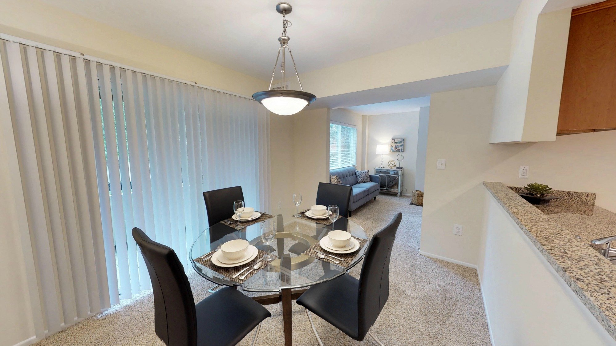 A dining room with a glass table and chairs.