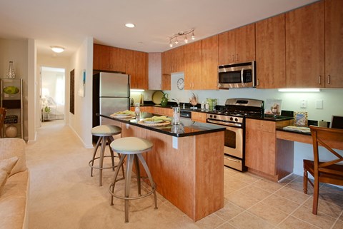 A kitchen with wooden cabinets and a black countertop.