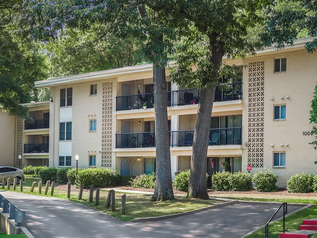 A white apartment building with balconies and trees in front. at Spa Cove Apartments, Annapolis, 21403