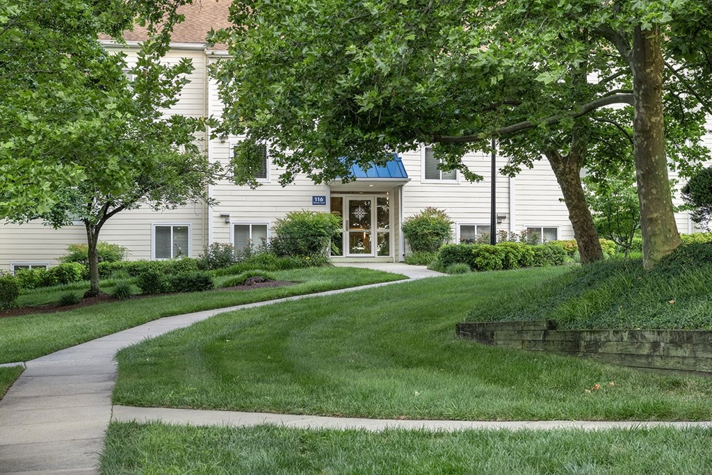 A building with a blue sign on it is surrounded by greenery. at West Woods, Annapolis, Maryland