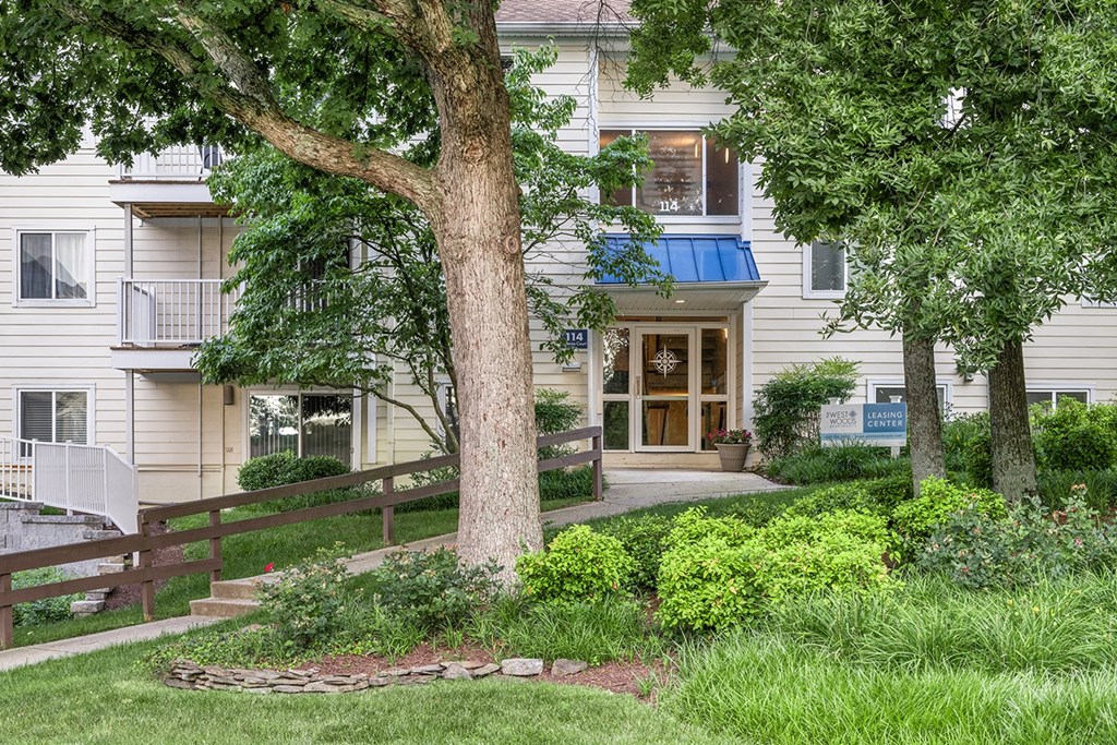 A tree in front of a building with a blue awning. at West Woods, Annapolis, Maryland