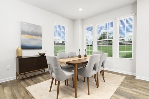 A dining room with a wooden table and chairs.