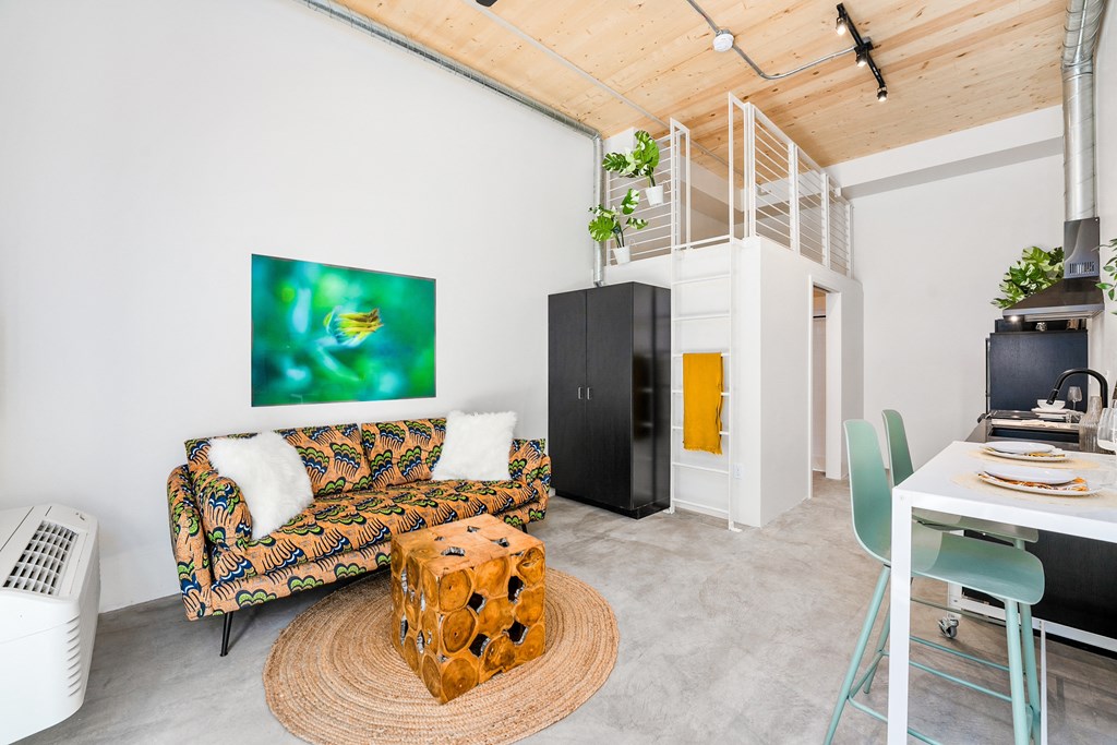 a living room with a couch and a table and a spiral staircase