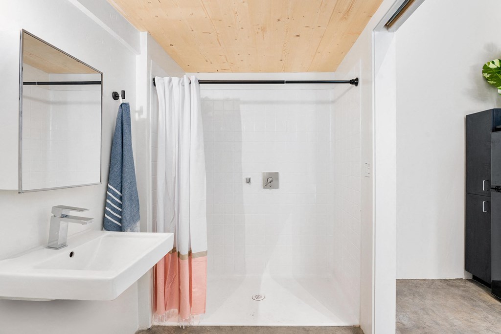 a white bathroom with a shower and a sink