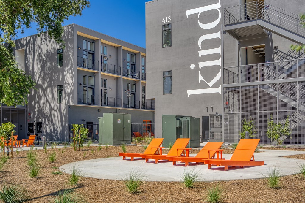 a group of orange chairs in front of an apartment building