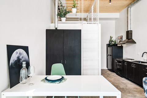 a kitchen and dining room with a white table and a black refrigerator