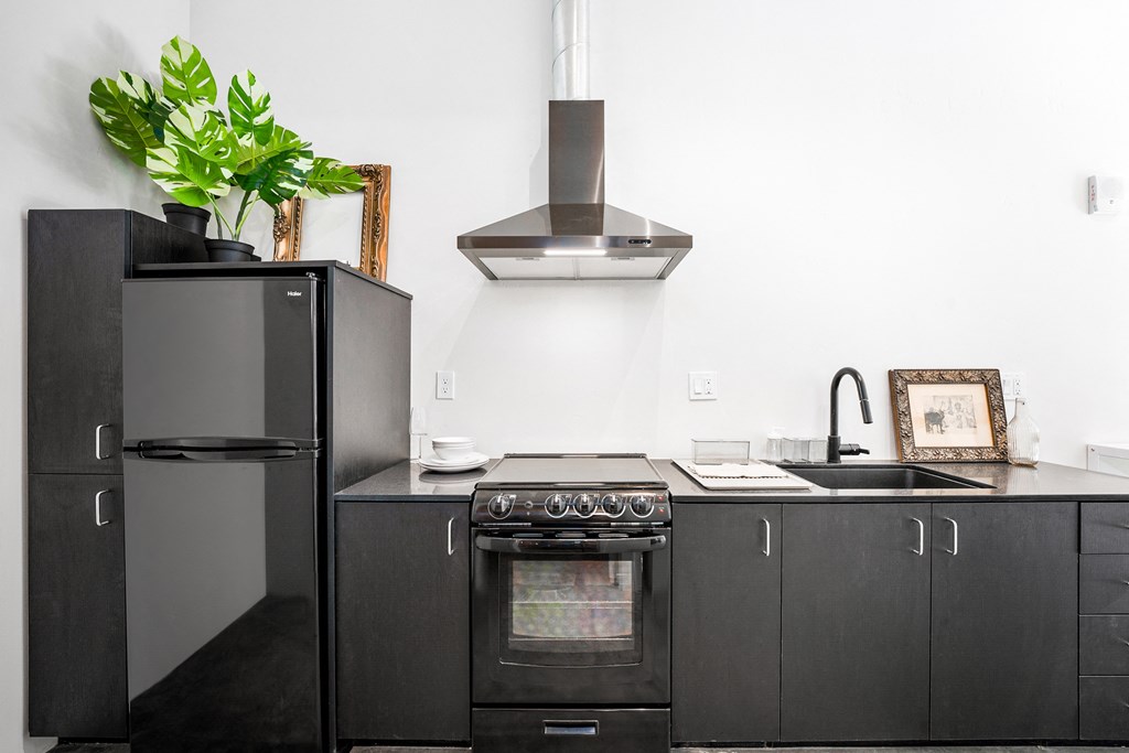 a kitchen with white walls and black cabinets