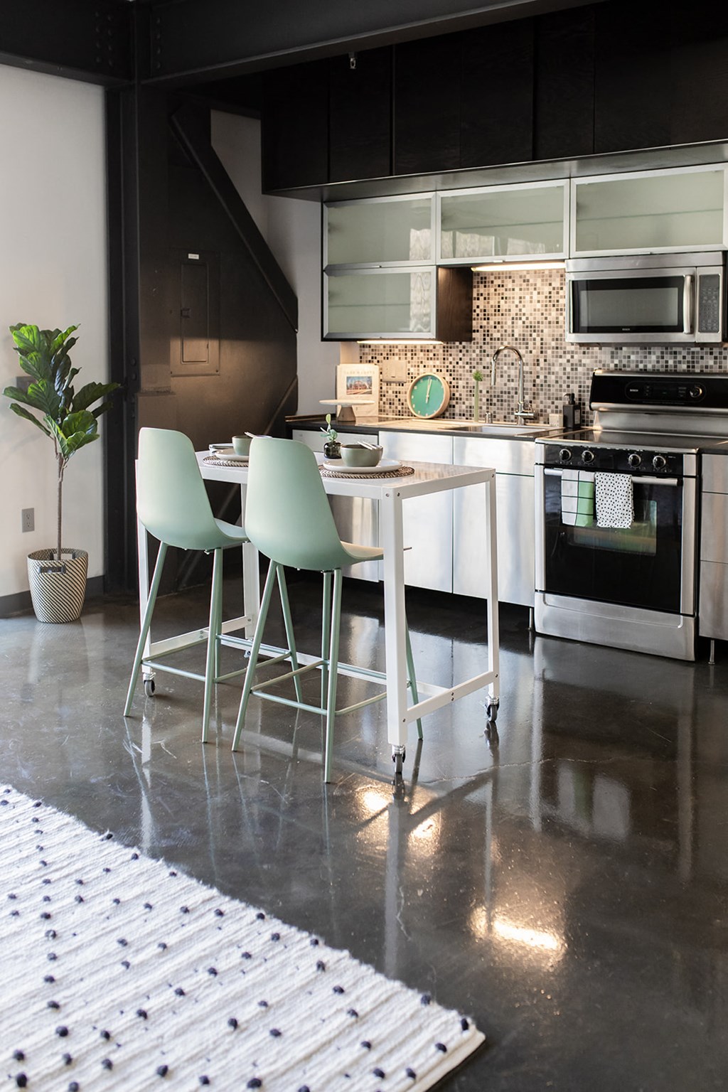 a kitchen with a white table and three green chairs