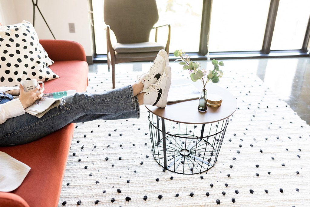a woman sitting on a couch with her feet up on a coffee table