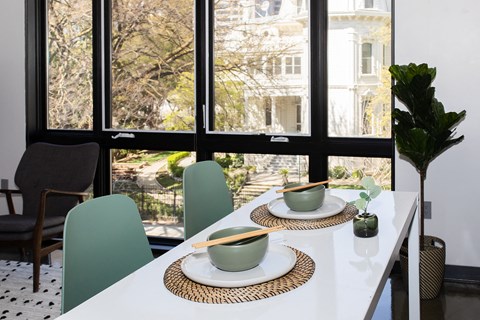 a dining table with two bowls and two chopsticks on it in front of a large window