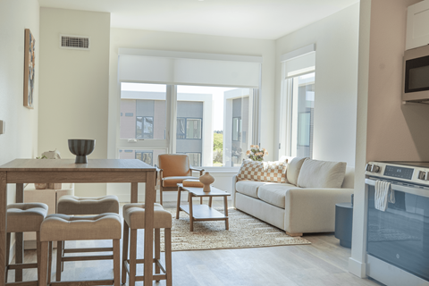 A modern living room with a dining table and chairs.