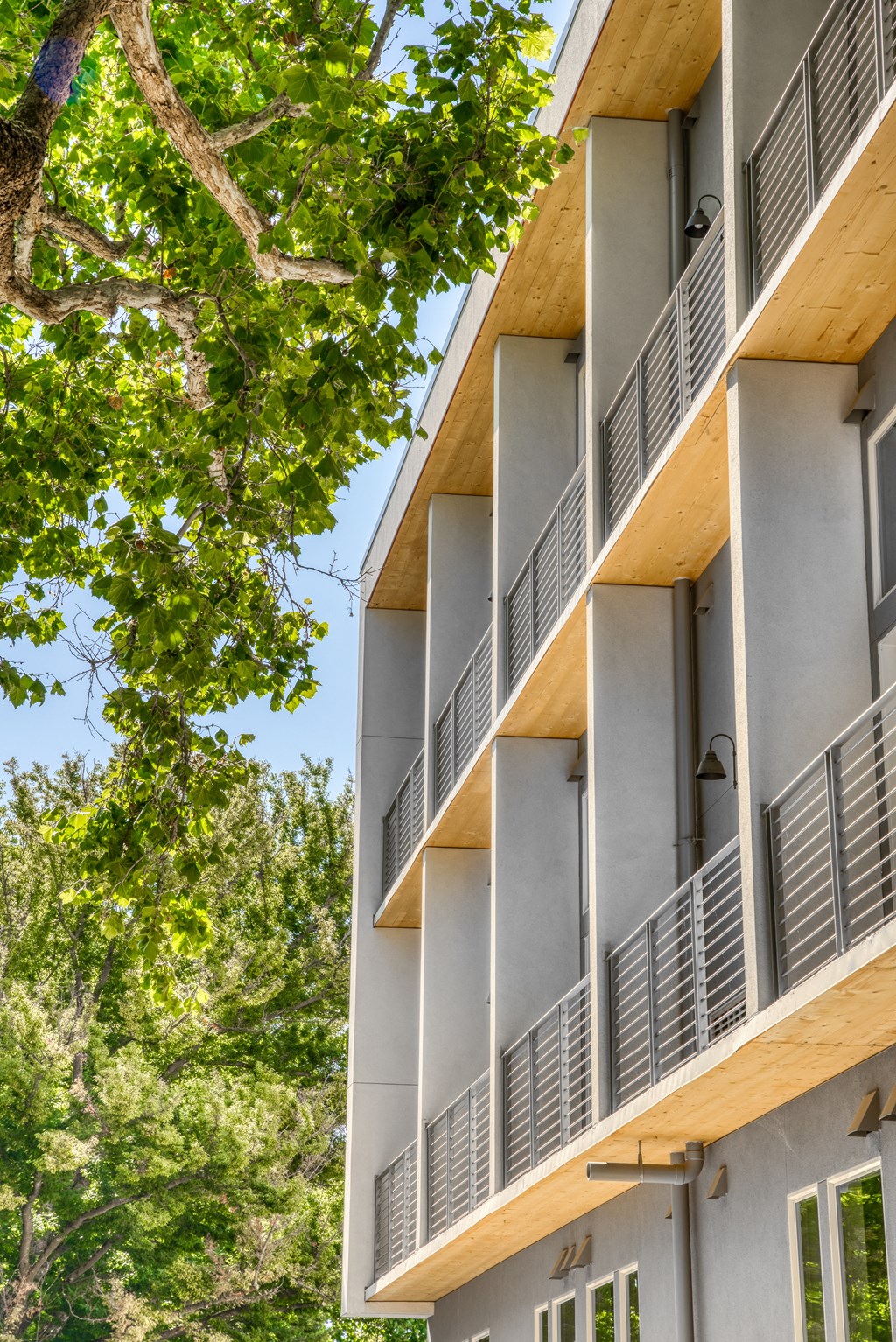 a view of the side of the building with trees in the foreground