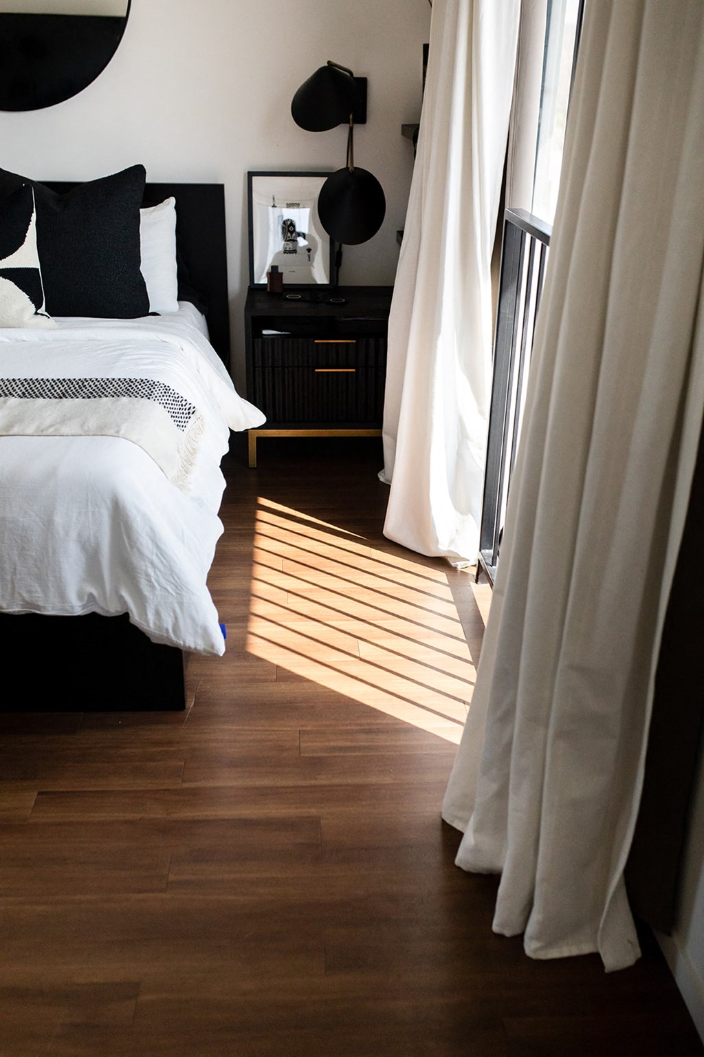 a bedroom with a bed and a wooden floor