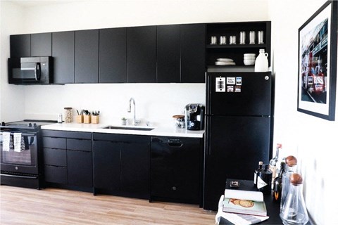 a kitchen with black cabinets and a black refrigerator