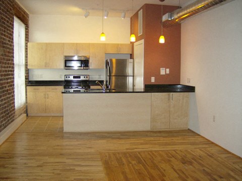 an empty kitchen with a stove and a refrigerator