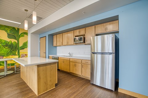 A kitchen with a wooden island and a stainless steel refrigerator.