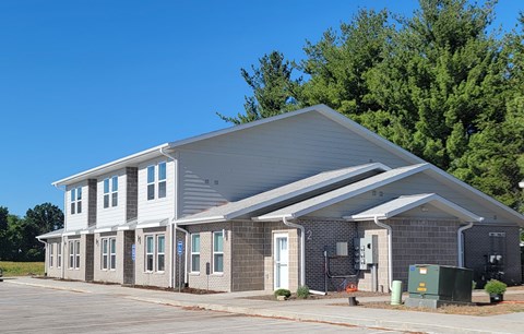 A modern building with a grey roof and white walls.