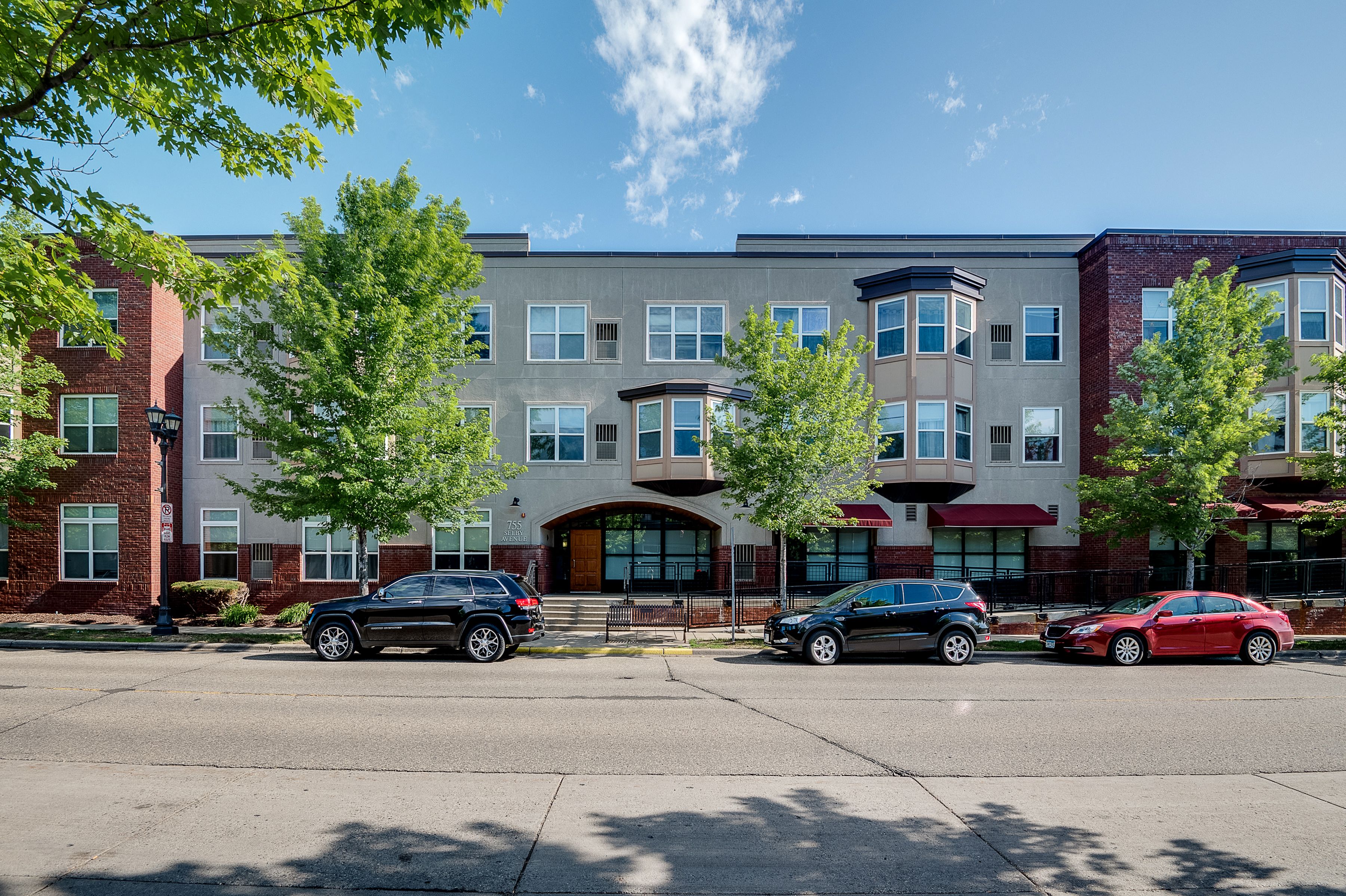A black car is parked in front of a building.