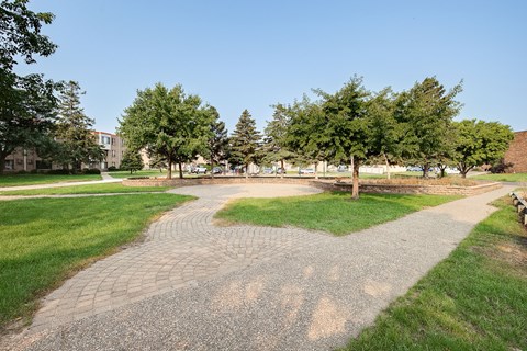 A pathway with grass on either side leads to a building in the distance.