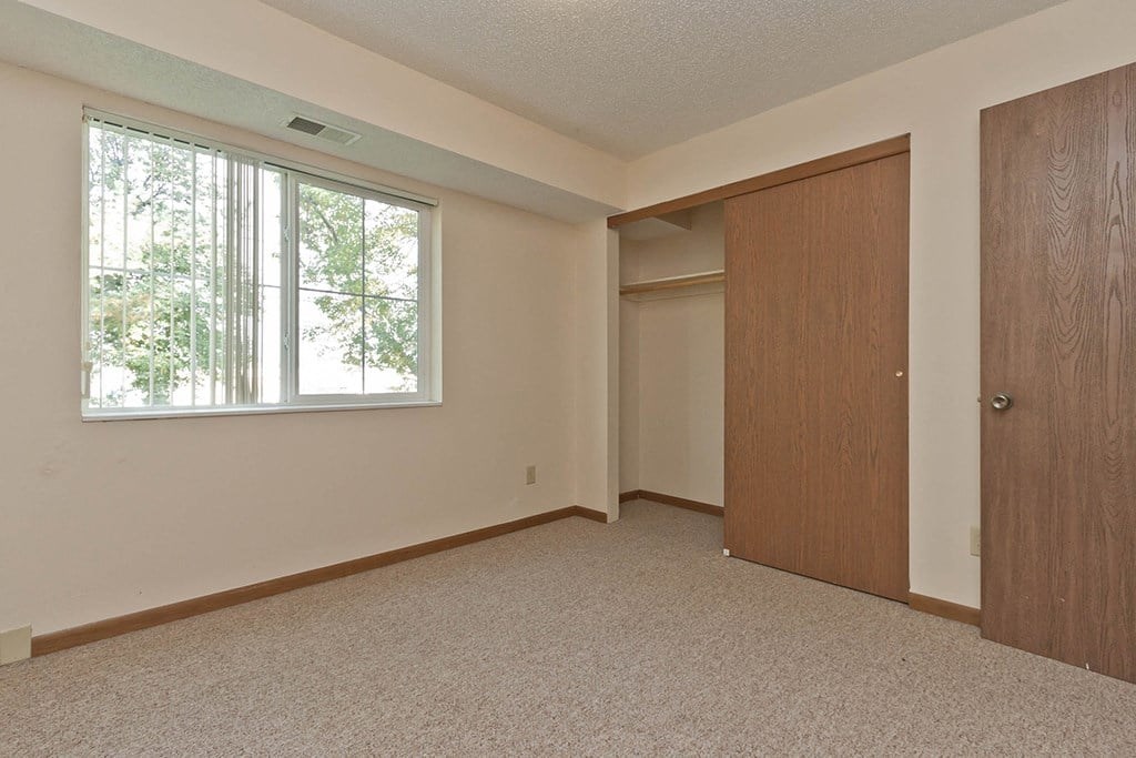 A room with a window and two doors.